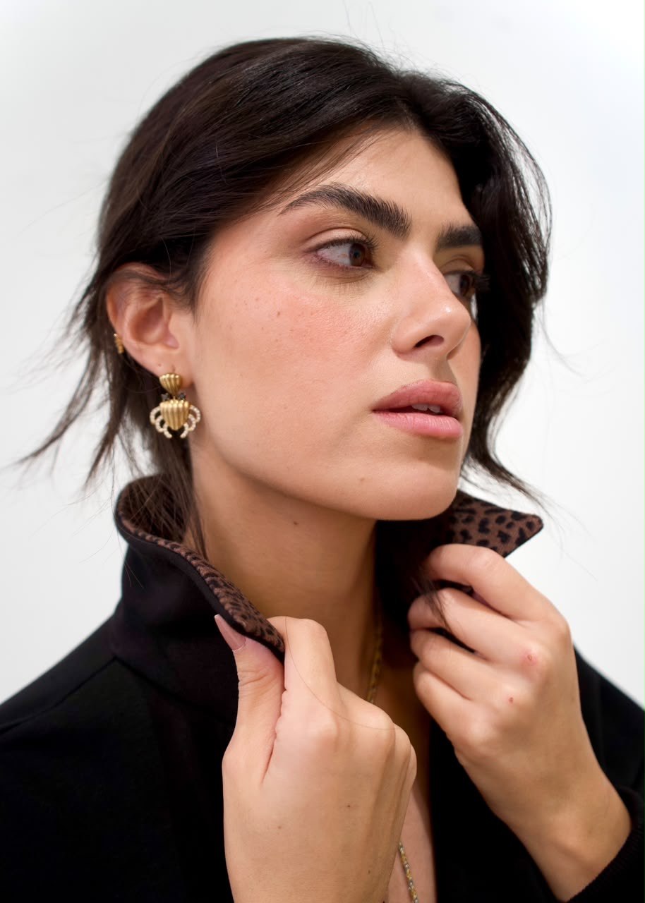 Close-up styling view of the raised brown cheetah-print collar on the black long sweater