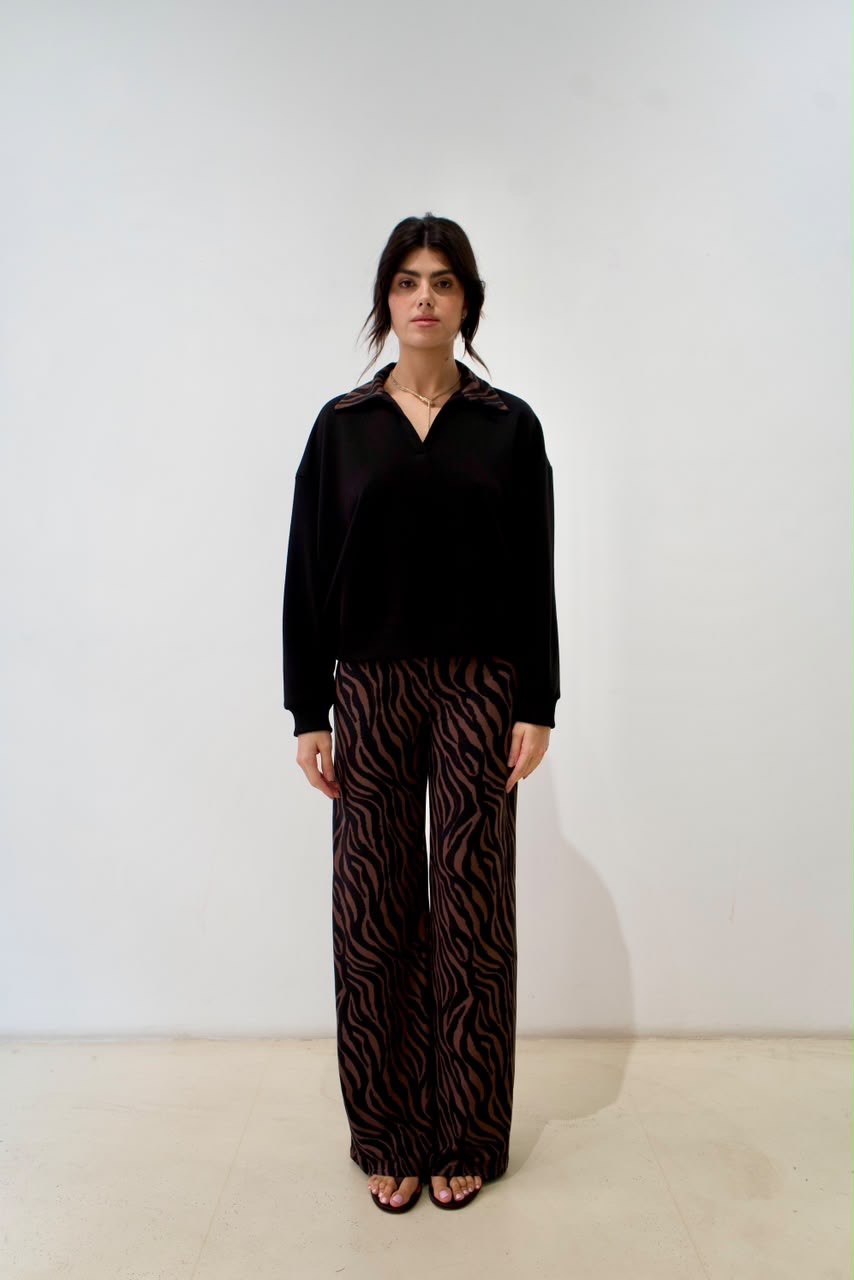 Full-length front styling view of the black short sweater with brown zebra-print collar