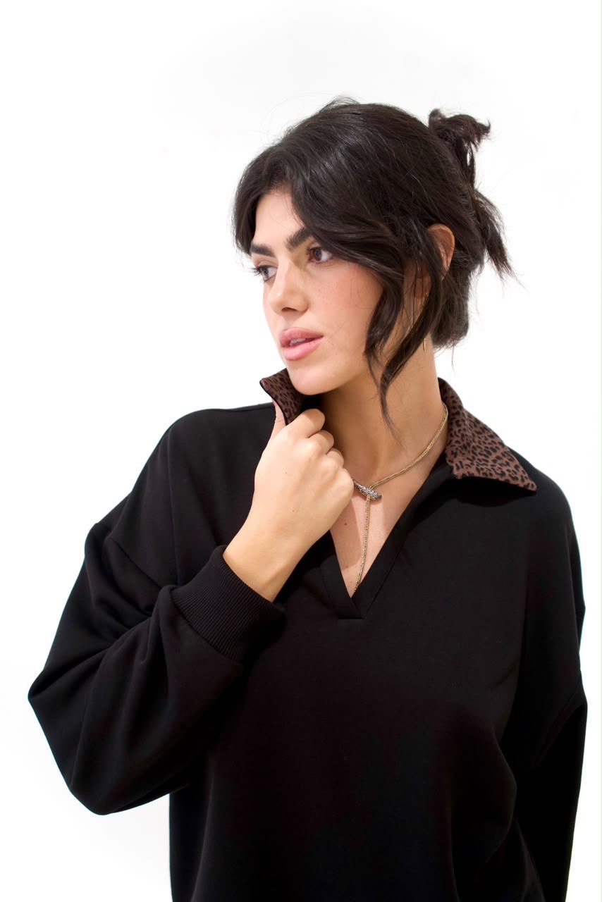 Front detail of the black long sweater with brown cheetah-print collar and ribbed cuff