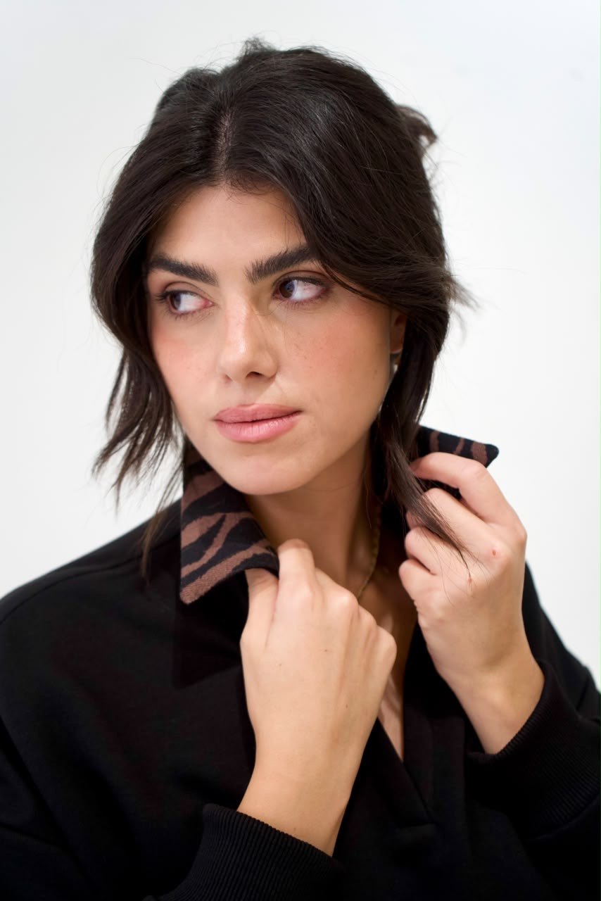 Close-up of the brown-and-black zebra-print collar on the black short sweater