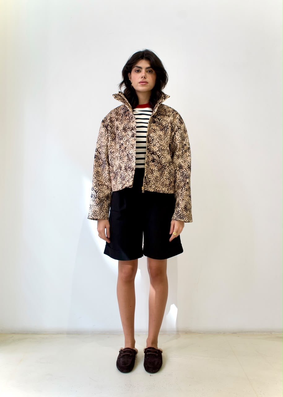 Full-length styling view of the cheetah-print bomber jacket with a raised collar, striped top and black shorts