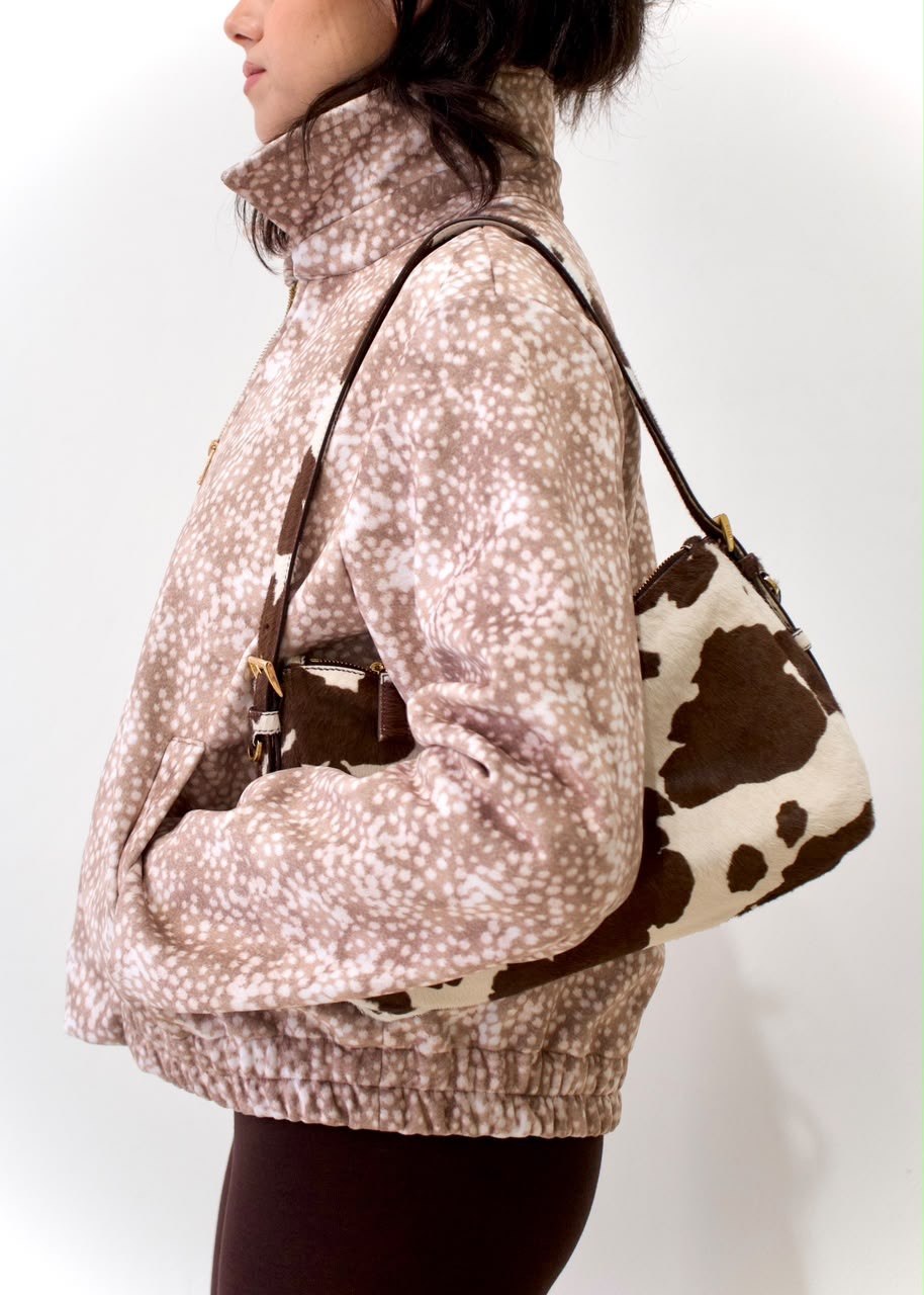 Side detail of the taupe-and-white spotted Bambi White Boy Jacket with raised collar, side pocket and gathered back hem